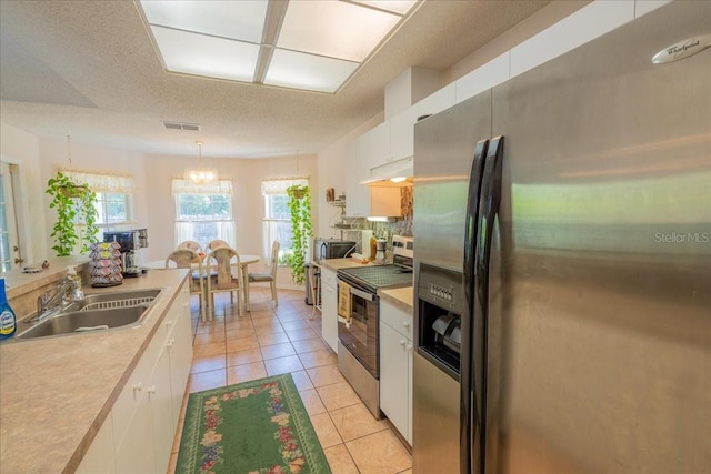 2826 Martha Ln, Land O Lakes, FL 34639 - kitchen featuring appliances with stainless steel finishes, a sink, under cabinet range hood, white cabinets, and light countertops