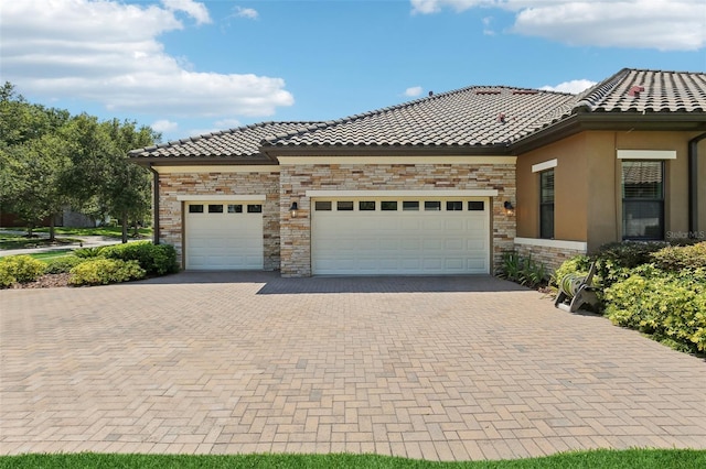 14715 Fishhawk Preserve Dr, Lithia, FL 33547 - view of front of property with decorative driveway, a tiled roof, an attached garage, and stone siding