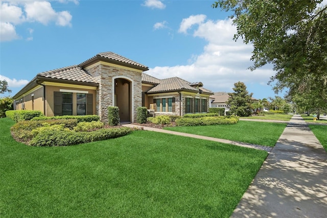 14715 Fishhawk Preserve Dr, Lithia, FL 33547 - mediterranean / spanish-style home featuring a tiled roof, stone siding, a front lawn, and stucco siding