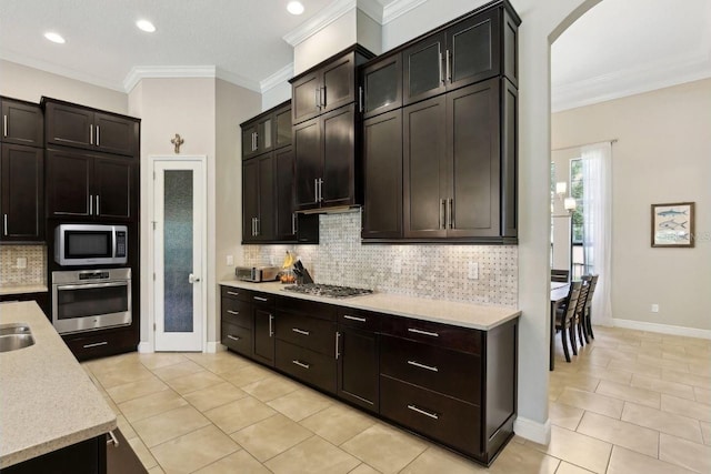 14715 Fishhawk Preserve Dr, Lithia, FL 33547 - kitchen featuring stainless steel appliances, tasteful backsplash, light tile patterned floors, ornamental molding, and arched walkways