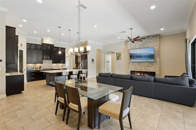 14715 Fishhawk Preserve Dr, Lithia, FL 33547 - dining area featuring ceiling fan, recessed lighting, light tile patterned floors, a stone fireplace, and arched walkways