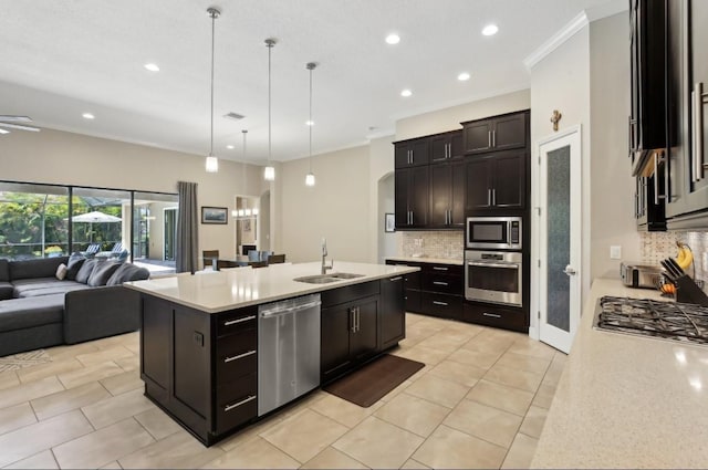 14715 Fishhawk Preserve Dr, Lithia, FL 33547 - kitchen featuring appliances with stainless steel finishes, a sink, open floor plan, light countertops, and tasteful backsplash