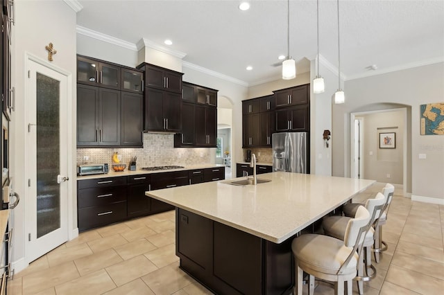 14715 Fishhawk Preserve Dr, Lithia, FL 33547 - kitchen with arched walkways, appliances with stainless steel finishes, a sink, backsplash, and ornamental molding