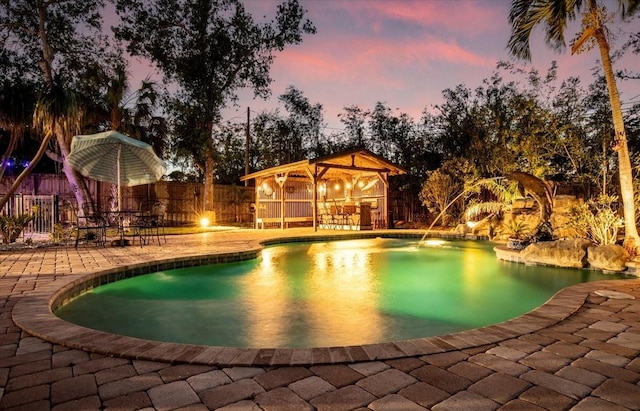 4301 S Lockwood Ridge Rd, Sarasota, FL 34231 - pool at dusk with a patio and a fenced backyard