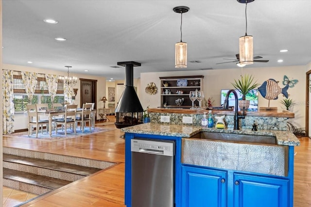 4301 S Lockwood Ridge Rd, Sarasota, FL 34231 - kitchen featuring dishwasher, a sink, blue cabinets, a chandelier, and a wood stove