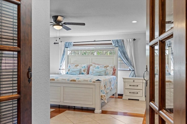 4301 S Lockwood Ridge Rd, Sarasota, FL 34231 - tiled bedroom featuring a textured wall and a ceiling fan
