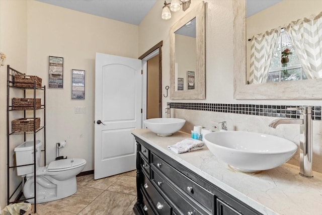 4301 S Lockwood Ridge Rd, Sarasota, FL 34231 - full bathroom with double vanity, tile patterned flooring, toilet, and backsplash