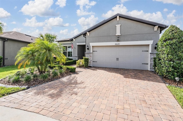 4620 Ballast Crest Cv, Land O Lakes, FL 34638 - view of front of home with stone siding, decorative driveway, stucco siding, and a garage