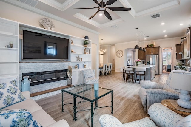 4620 Ballast Crest Cv, Land O Lakes, FL 34638 - living room with ornamental molding, a ceiling fan, light wood-type flooring, a fireplace, and a chandelier
