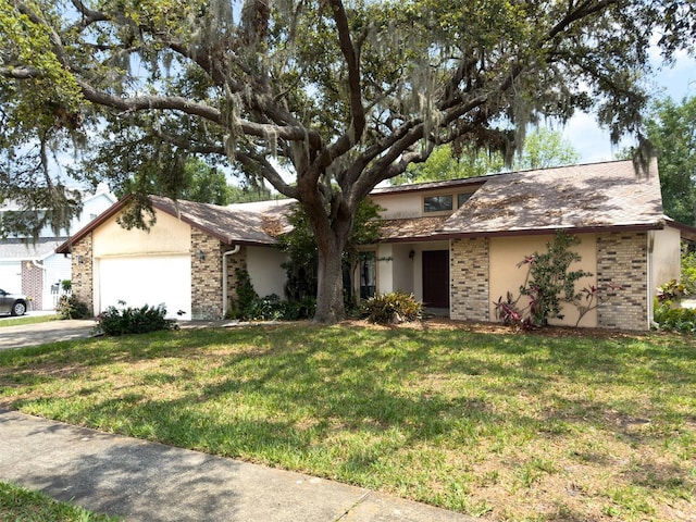 1228 Rainbrook Cir, Valrico, FL 33596 - view of front of property featuring brick siding, a garage, a front lawn, driveway, and stucco siding
