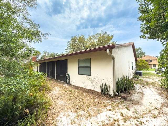 1228 Rainbrook Cir, Valrico, FL 33596 - view of side of property featuring a sunroom, stucco siding, and central air condition unit
