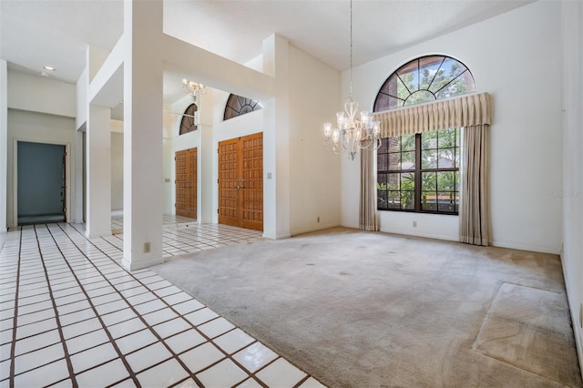 707 Warren Rd, Lutz, FL 33548 - empty room featuring carpet floors, a chandelier, a towering ceiling, and baseboards