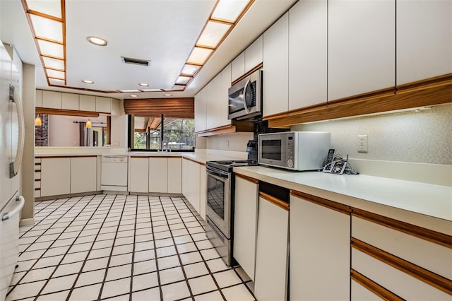707 Warren Rd, Lutz, FL 33548 - kitchen featuring stainless steel appliances, light countertops, white cabinets, recessed lighting, and decorative backsplash