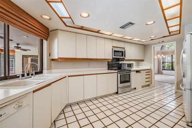 707 Warren Rd, Lutz, FL 33548 - kitchen featuring appliances with stainless steel finishes, a sink, light countertops, white cabinets, and recessed lighting