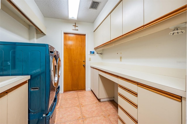 707 Warren Rd, Lutz, FL 33548 - laundry area with washing machine and clothes dryer, a textured ceiling, cabinet space, a desk, and light tile patterned floors