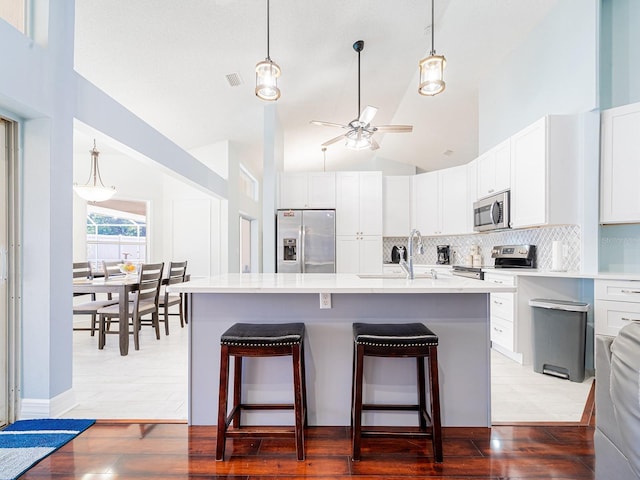 382 Florian Way, Spring Hill, FL 34609 - kitchen with stainless steel appliances, tasteful backsplash, a kitchen bar, ceiling fan, and high vaulted ceiling