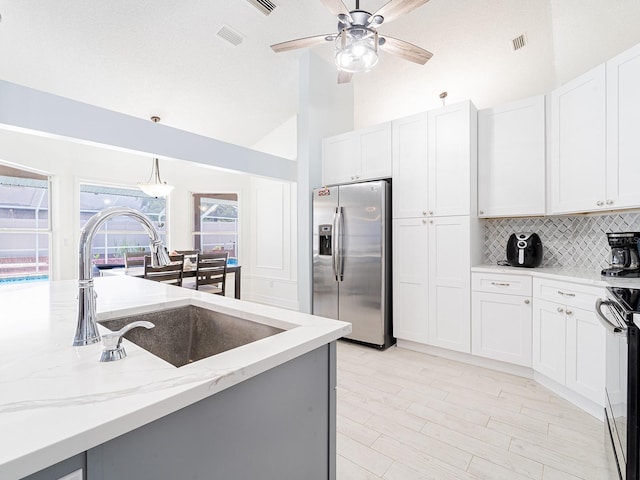 382 Florian Way, Spring Hill, FL 34609 - kitchen featuring stainless steel fridge with ice dispenser, a sink, backsplash, light stone counters, and pendant lighting