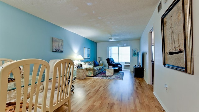 3534 Lake Bayshore Dr Unit 118, Bradenton, FL 34205 - living room featuring a textured ceiling, light wood-type flooring, and baseboards