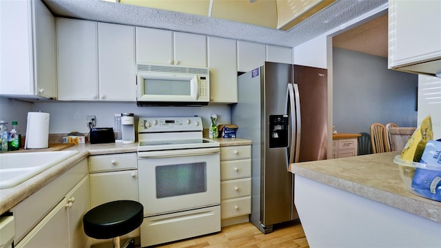 3534 Lake Bayshore Dr Unit 118, Bradenton, FL 34205 - kitchen with white appliances, light wood-style floors, and light countertops