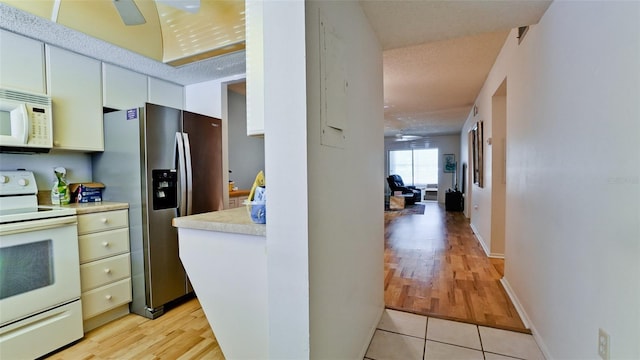 3534 Lake Bayshore Dr Unit 118, Bradenton, FL 34205 - kitchen featuring white appliances, light countertops, a ceiling fan, and light wood-type flooring