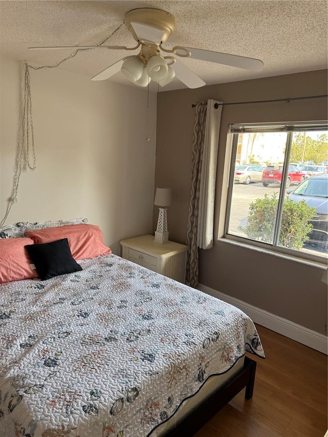 3534 Lake Bayshore Dr Unit 118, Bradenton, FL 34205 - bedroom with baseboards, wood finished floors, a textured ceiling, and a ceiling fan
