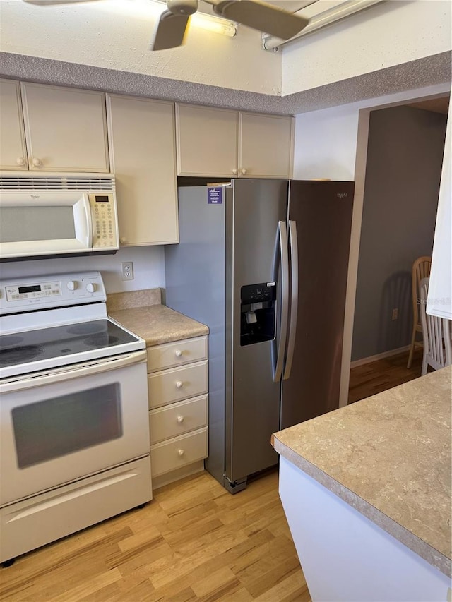 3534 Lake Bayshore Dr Unit 118, Bradenton, FL 34205 - kitchen with white appliances, light wood-type flooring, and light countertops