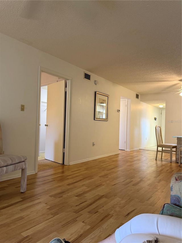 3534 Lake Bayshore Dr Unit 118, Bradenton, FL 34205 - living area with light wood-type flooring, a textured ceiling, ceiling fan, and baseboards