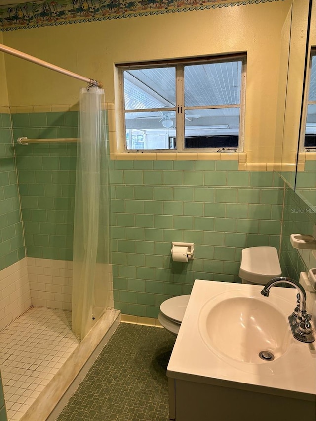 5008 N Suwanee Ave, Tampa, FL 33603 - bathroom featuring toilet, a shower stall, a wainscoted wall, vanity, and tile walls