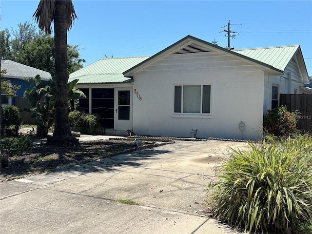 5008 N Suwanee Ave, Tampa, FL 33603 - rear view of house with concrete block siding, metal roof, and a patio