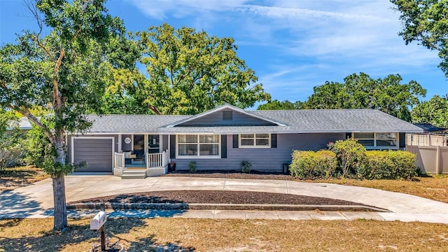 504 7th Ave SW, Largo, FL 33770 - ranch-style home with covered porch, a garage, driveway, and roof with shingles