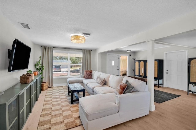 504 7th Ave SW, Largo, FL 33770 - living area featuring light wood-type flooring, a textured ceiling, and baseboards