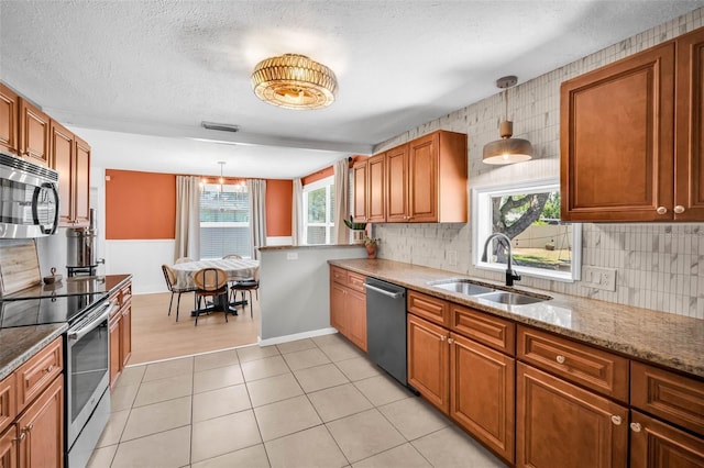504 7th Ave SW, Largo, FL 33770 - kitchen with appliances with stainless steel finishes, a sink, brown cabinetry, backsplash, and a textured ceiling
