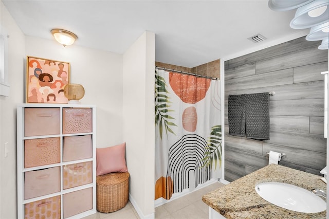 504 7th Ave SW, Largo, FL 33770 - bathroom with vanity, tile patterned flooring, a shower with shower curtain, baseboards, and tile walls