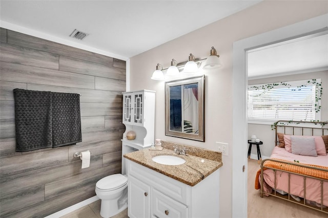 504 7th Ave SW, Largo, FL 33770 - bathroom featuring vanity, toilet, ensuite bathroom, and wood finished floors