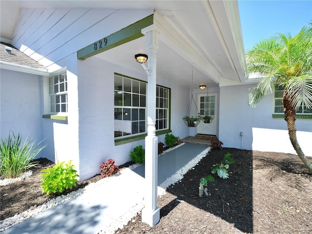 829 Riverside Dr, Tarpon Springs, FL 34689 - doorway to property with stucco siding and covered porch