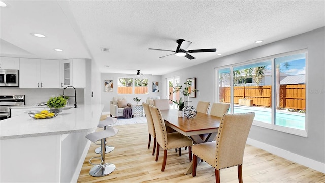 829 Riverside Dr, Tarpon Springs, FL 34689 - dining space featuring light wood-style flooring, baseboards, a textured ceiling, ceiling fan, and recessed lighting