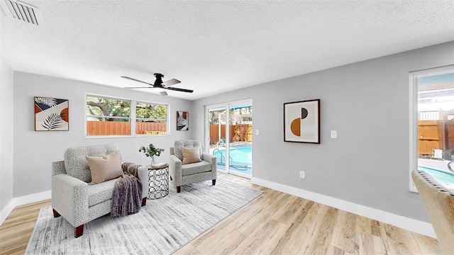 829 Riverside Dr, Tarpon Springs, FL 34689 - sitting room featuring a textured ceiling, wood finished floors, a ceiling fan, and baseboards