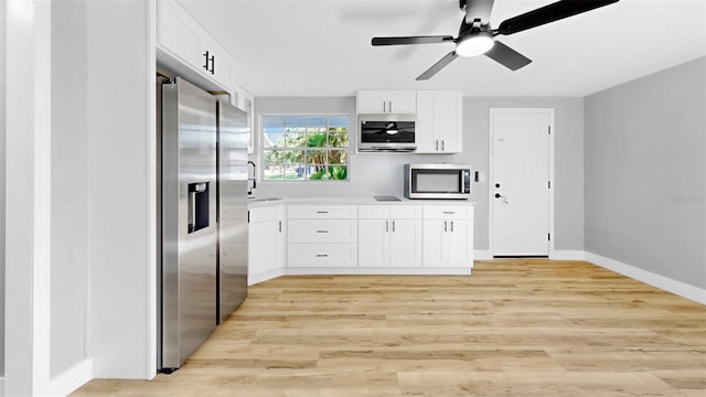 829 Riverside Dr, Tarpon Springs, FL 34689 - kitchen with appliances with stainless steel finishes, a ceiling fan, white cabinetry, light countertops, and a sink