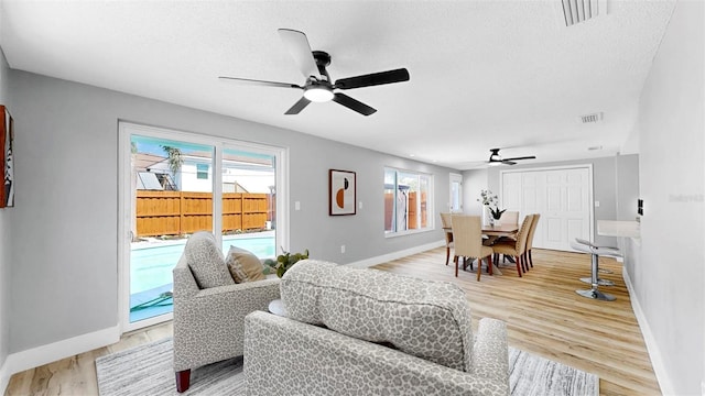 829 Riverside Dr, Tarpon Springs, FL 34689 - living room with ceiling fan, baseboards, a textured ceiling, and light wood-type flooring