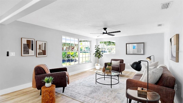 829 Riverside Dr, Tarpon Springs, FL 34689 - living area with ceiling fan, light wood-style flooring, baseboards, and a textured ceiling