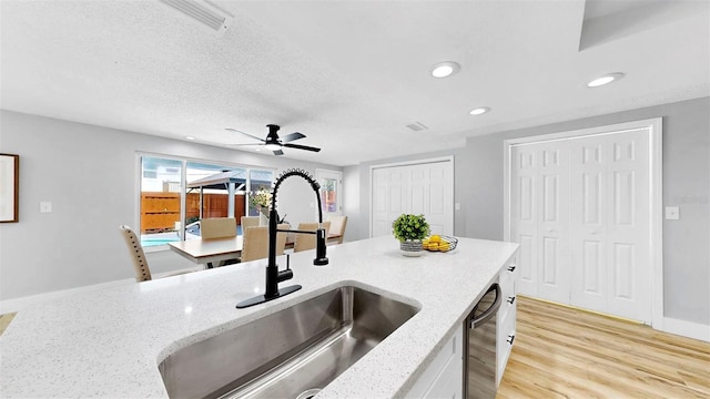 829 Riverside Dr, Tarpon Springs, FL 34689 - kitchen with a sink, recessed lighting, light wood-type flooring, ceiling fan, and light stone countertops