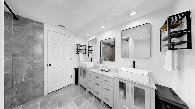 829 Riverside Dr, Tarpon Springs, FL 34689 - full bathroom with marble look tile flooring, double vanity, recessed lighting, and tiled shower