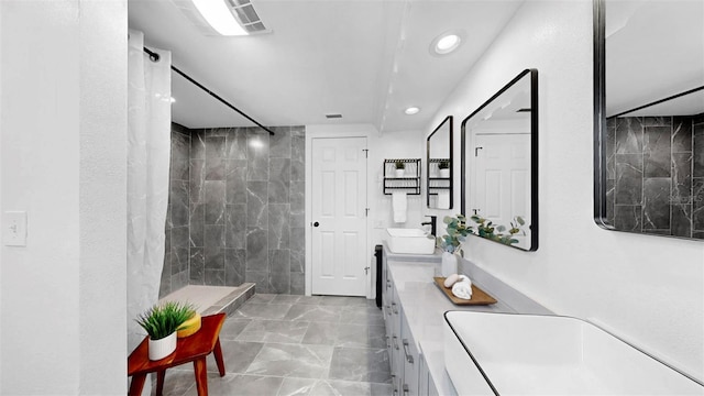 829 Riverside Dr, Tarpon Springs, FL 34689 - full bath with double vanity, marble finish floors, recessed lighting, and a tile shower