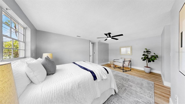 829 Riverside Dr, Tarpon Springs, FL 34689 - bedroom with wood finished floors, a textured ceiling, baseboards, and a ceiling fan