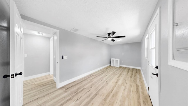 829 Riverside Dr, Tarpon Springs, FL 34689 - empty room featuring light wood-type flooring, ceiling fan, a textured ceiling, and baseboards