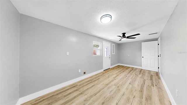 829 Riverside Dr, Tarpon Springs, FL 34689 - empty room with light wood-style flooring, baseboards, a textured ceiling, and ceiling fan