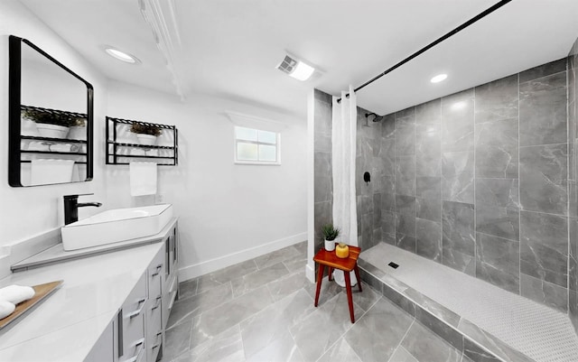 829 Riverside Dr, Tarpon Springs, FL 34689 - bathroom featuring double vanity, recessed lighting, a tile shower, and baseboards