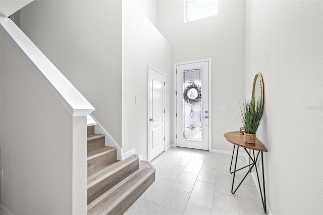 6563 Ryestone Way, Wesley Chapel, FL 33545 - foyer entrance with stairway, a towering ceiling, light tile patterned floors, and baseboards