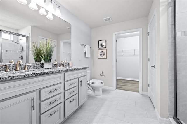 6563 Ryestone Way, Wesley Chapel, FL 33545 - bathroom featuring a walk in closet, double vanity, toilet, and a shower stall
