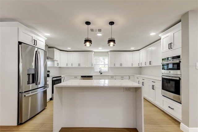 10744 Drummond Rd, Tampa, FL 33615 - kitchen featuring appliances with stainless steel finishes, a sink, light countertops, a center island, and recessed lighting
